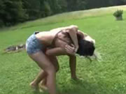 Duas mulheres lutaram na grama.