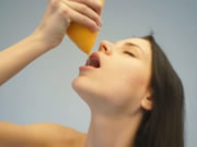 Adolescente nu bebendo suco de laranja