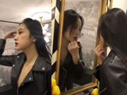 Uma bela mulher asiática a aplicar maquilhagem